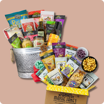 Assorted gourmet snack basket and gift box with a variety of products on a beige background