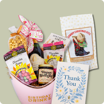Gift basket with snacks, drinks, and cards on a light green background
