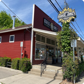 Red building with 'Maisie Jane's' sign and logo on a sunny day