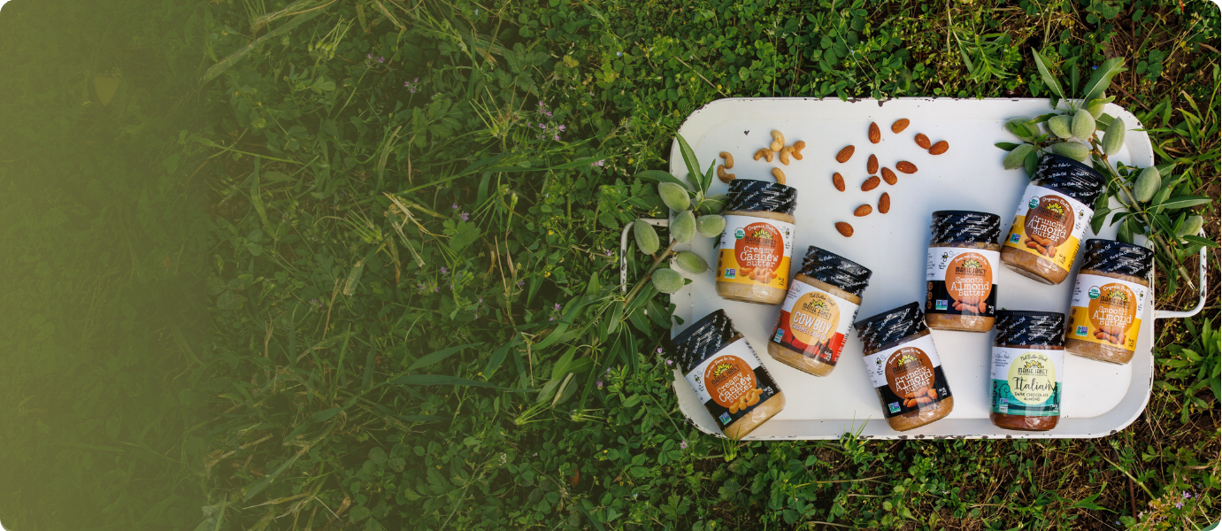 Assorted nut butters on a tray with a grass background