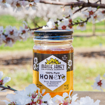 Jar of Maisie Janes 100% Pure Honey with almond blooms