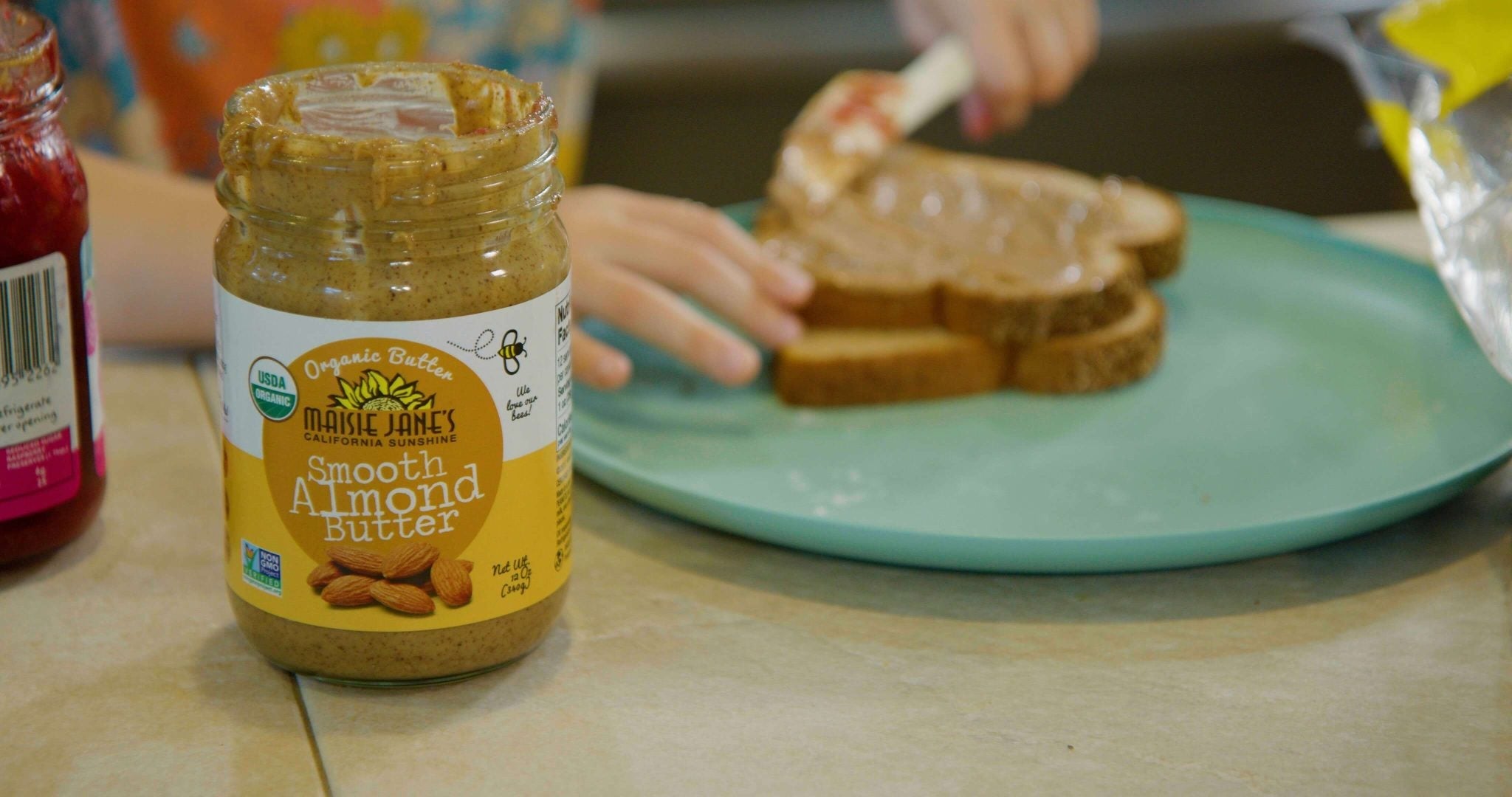 Almond butter being spread on toast 