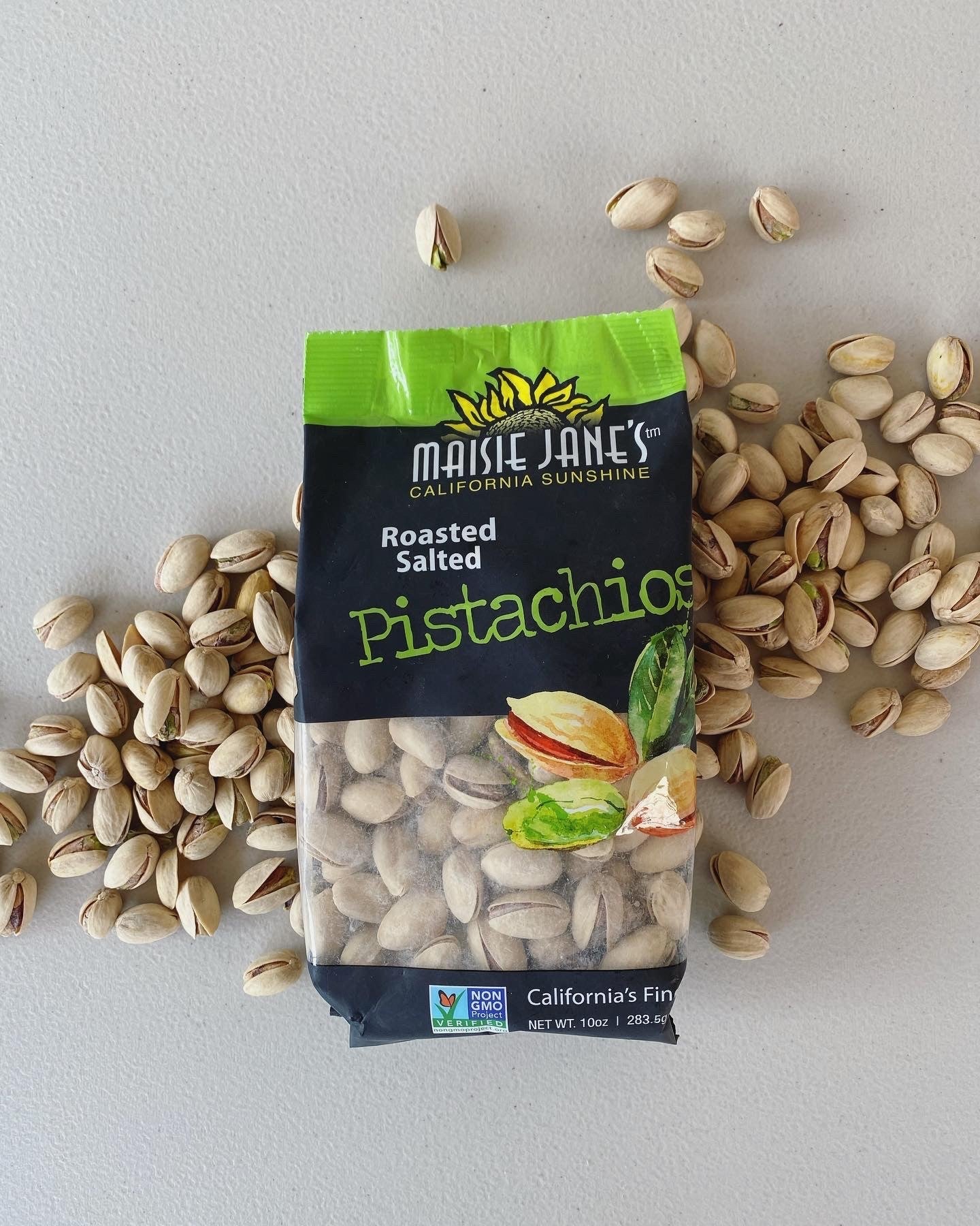 open bag of Maisie Janes Pistachios on a pile of nuts