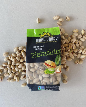 open bag of Maisie Janes Pistachios on a pile of nuts