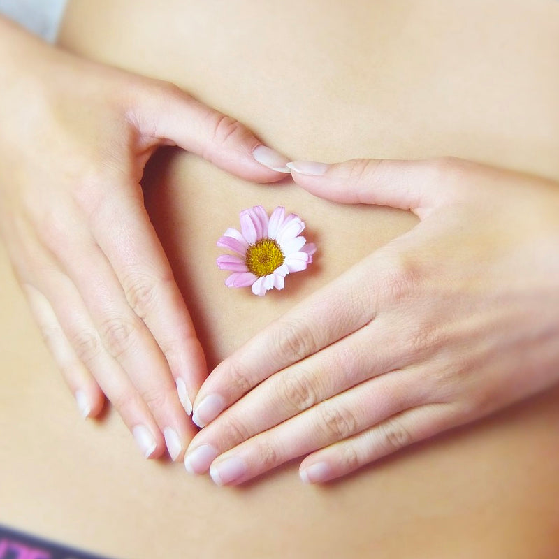 hands over belly button with a flower