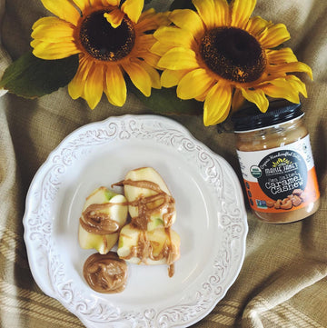 plate of apple slices with nut butter drizzled over the top