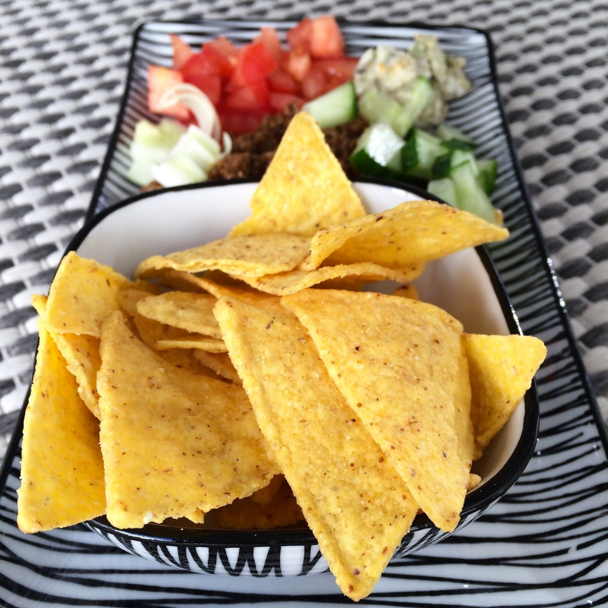 plate of tortilla chips and chopped onions and tomatoes