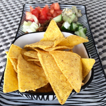 plate of tortilla chips and chopped onions and tomatoes