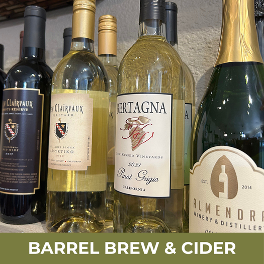 Collection of wine bottles with visible labels on a wooden surface, featuring the text 'Barrel Brew & Cider'.