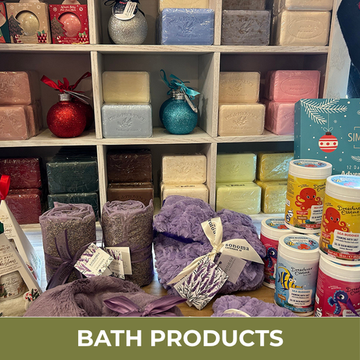 Display of bath products including soaps, bath bombs, and other items on shelves.